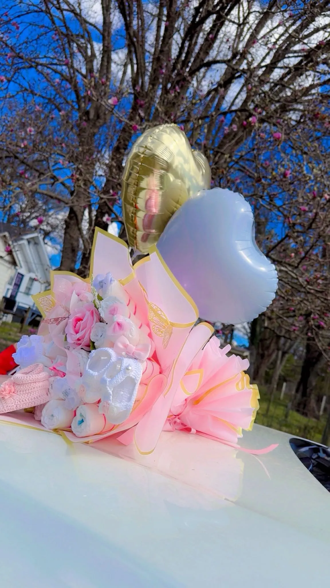 Ramo rosa con globos dorados y blancos con un cielo azul de fondo