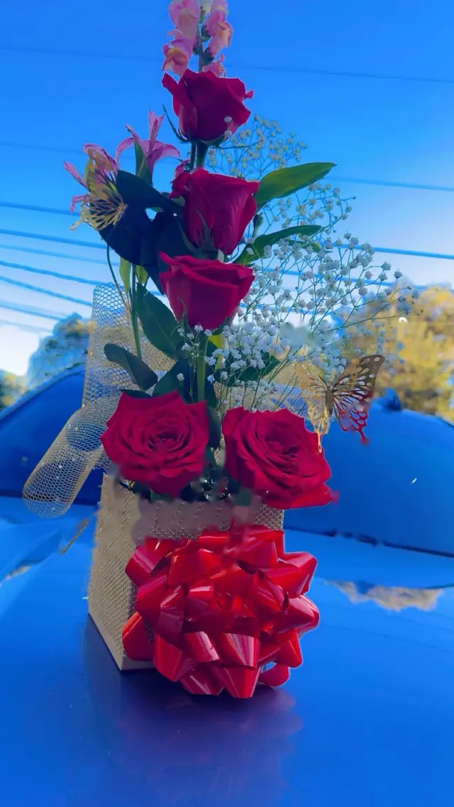Arreglo alto de rosas rojas con moño rojo