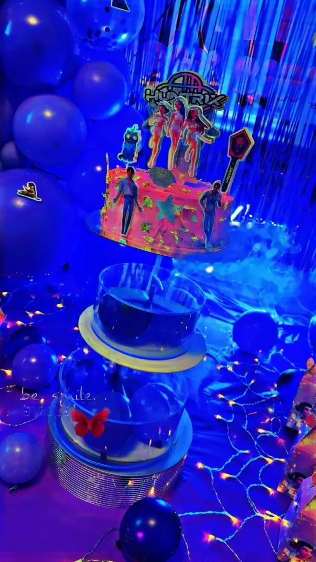 Mesa de pastel con globos azules y luces