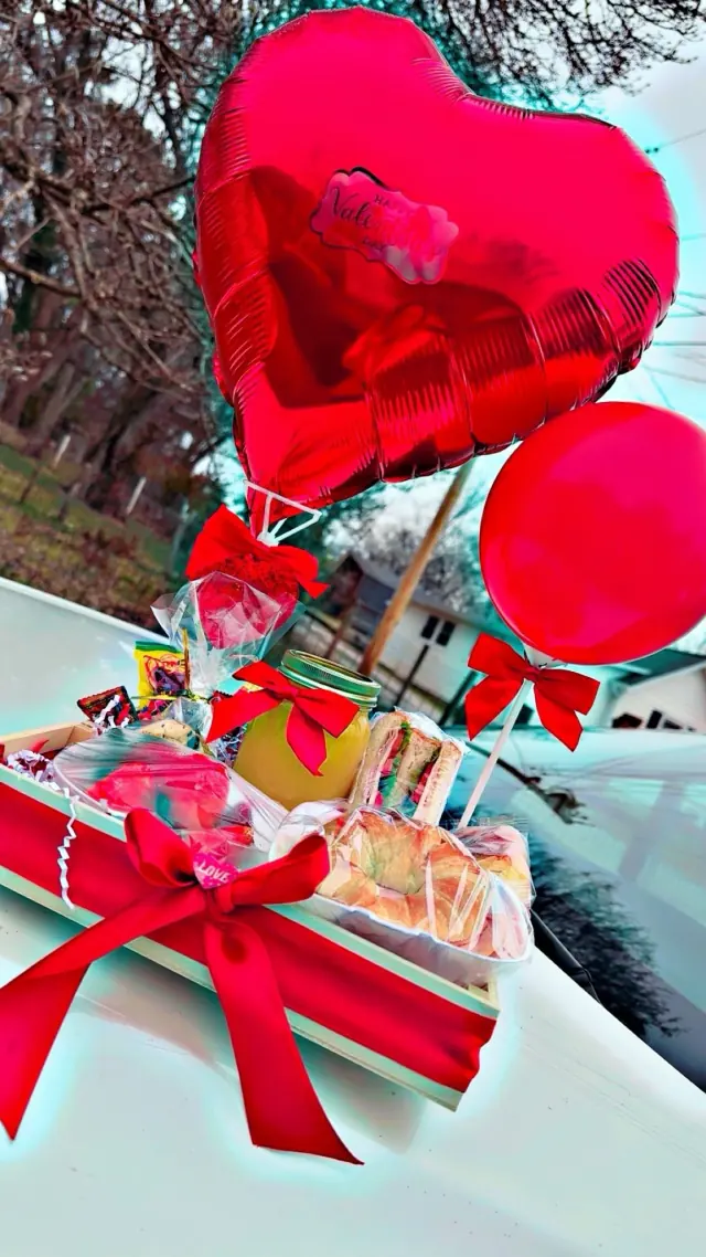 Caja de regalo con globos rojos de corazón y moños